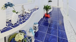 Une salle de bain moderne avec un sol carrelé de bleu, des murs blancs et un meuble-lavabo incurvé agrémenté d’un miroir.