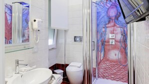 Une salle de bain moderne avec une douche à parois de verre, un lavabo blanc et des toilettes.