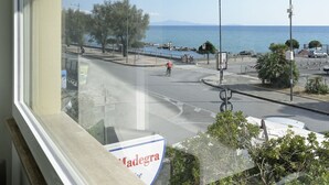 Une vue d’une rue côtière, avec un ciel dégagé, un cycliste et un panneau indiquant « Madegra ».