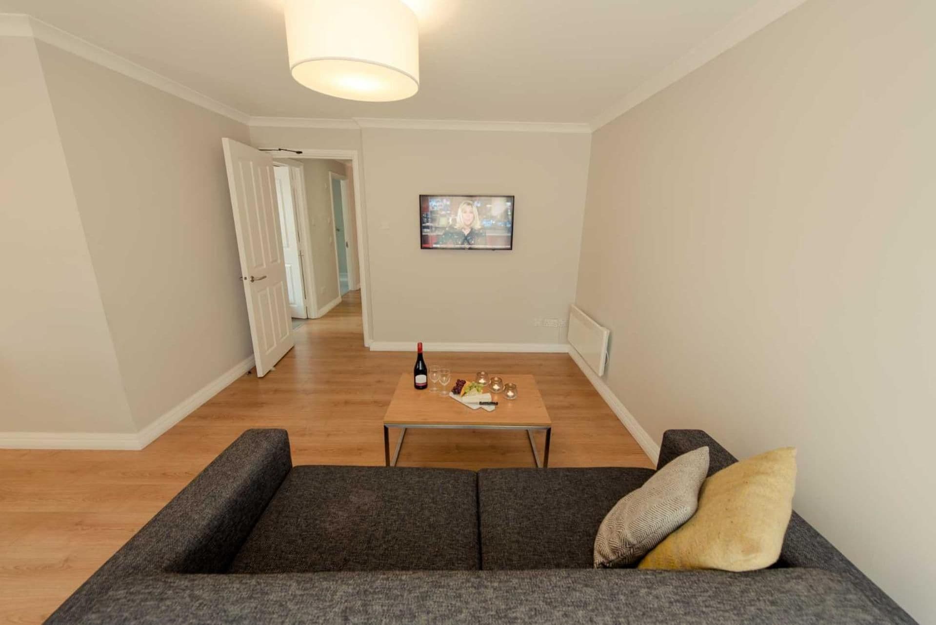 Ein Wohnzimmer mit einer Couch, einem Couchtisch und einem Fernseher.