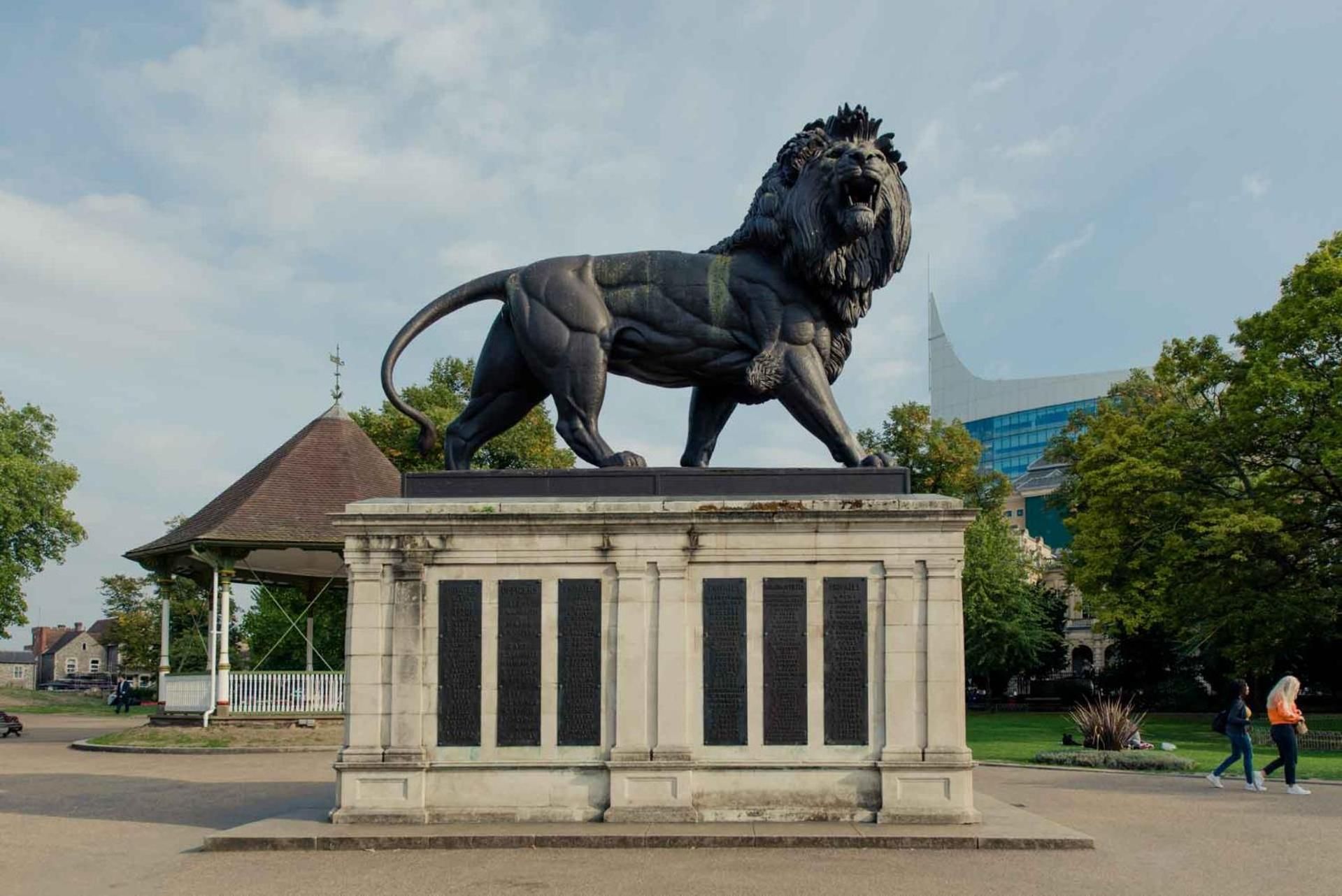 A lion statue on a pedestal in an outdoor setting.