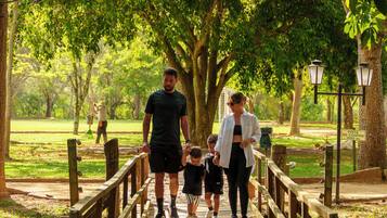 A wooden bridge in a park with people walking.