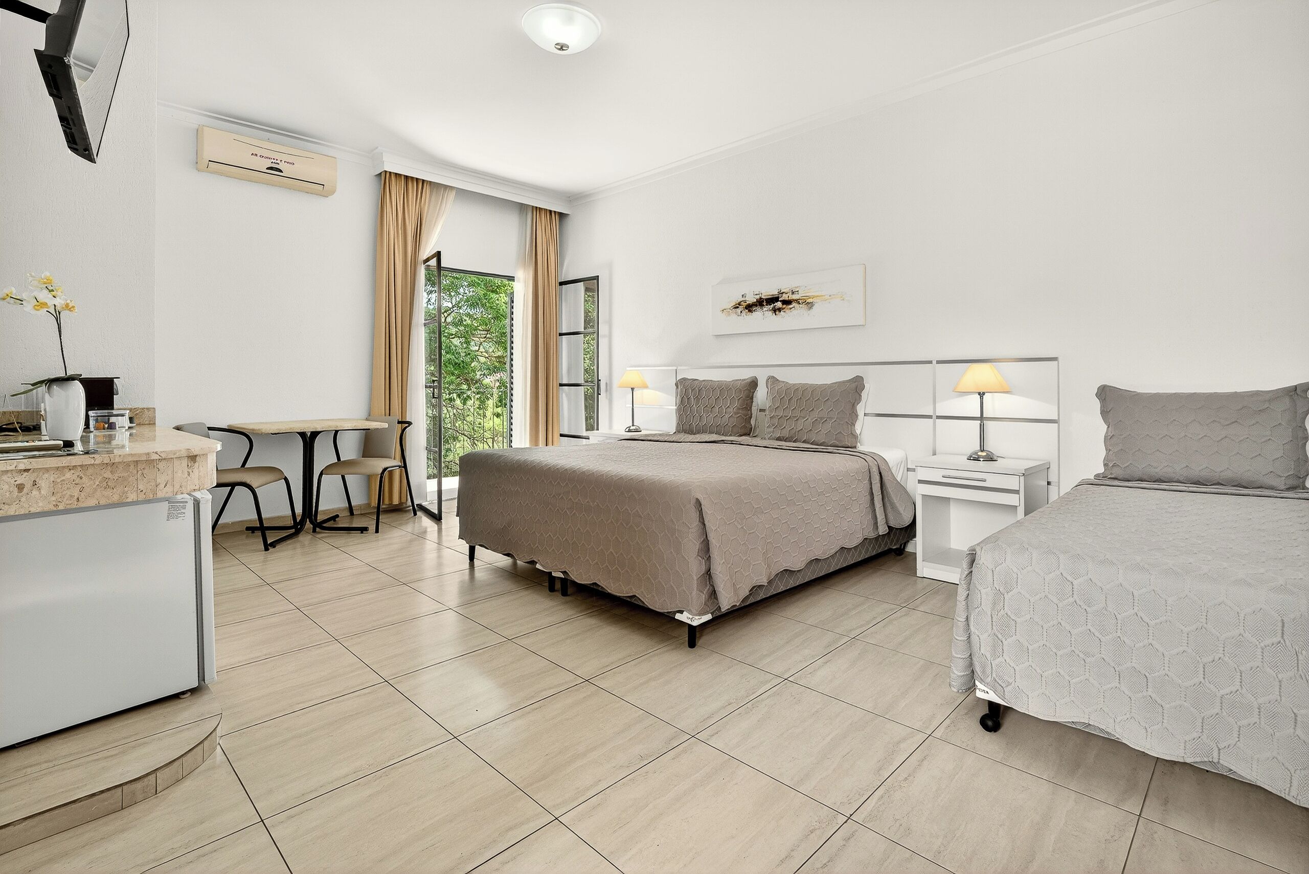 Una habitación de hotel moderna con cama, mesitas de noche, escritorio y una silla.