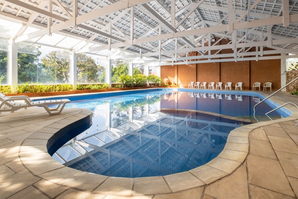 Een binnenzwembad, een buitenzwembad, parasols voor strand/zwembad