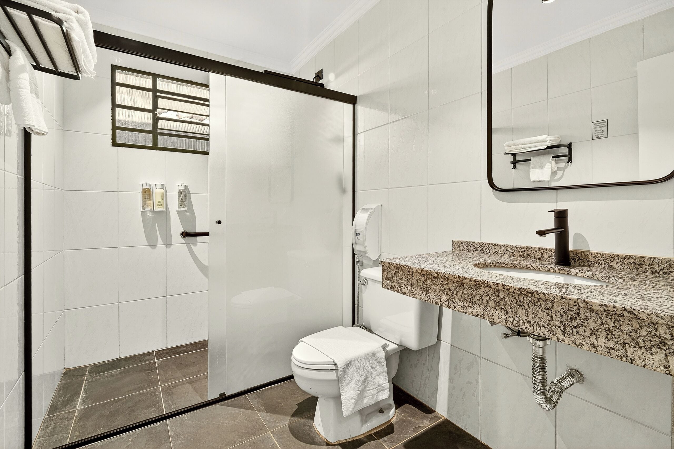A modern bathroom with a toilet, sink, and shower.
