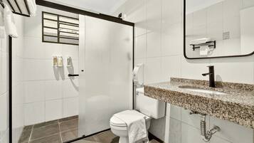 A modern bathroom with a toilet, sink, and shower.
