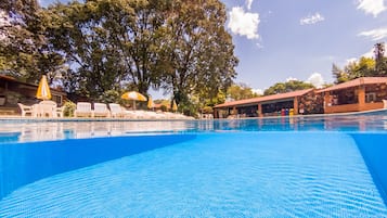 Piscine couverte, piscine extérieure, parasols de plage, chaises longues