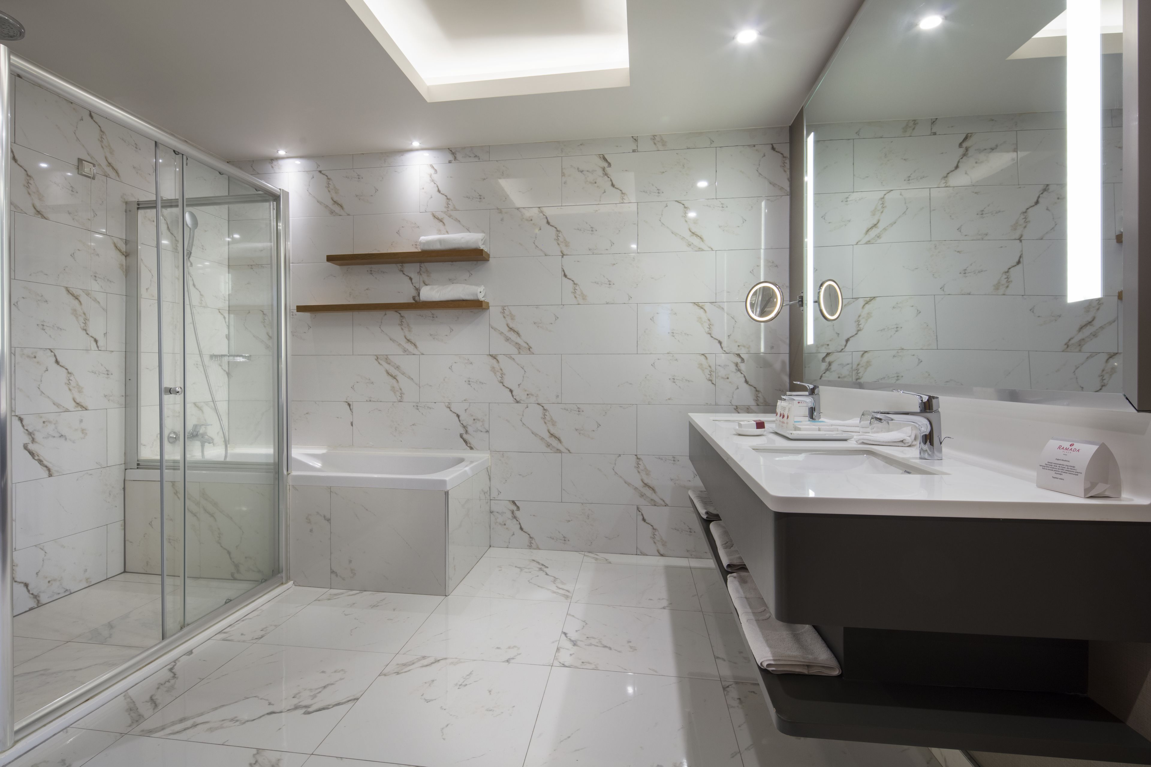 Une salle de bain moderne avec une douche à parois de verre, une baignoire et un meuble-lavabo avec un miroir.
