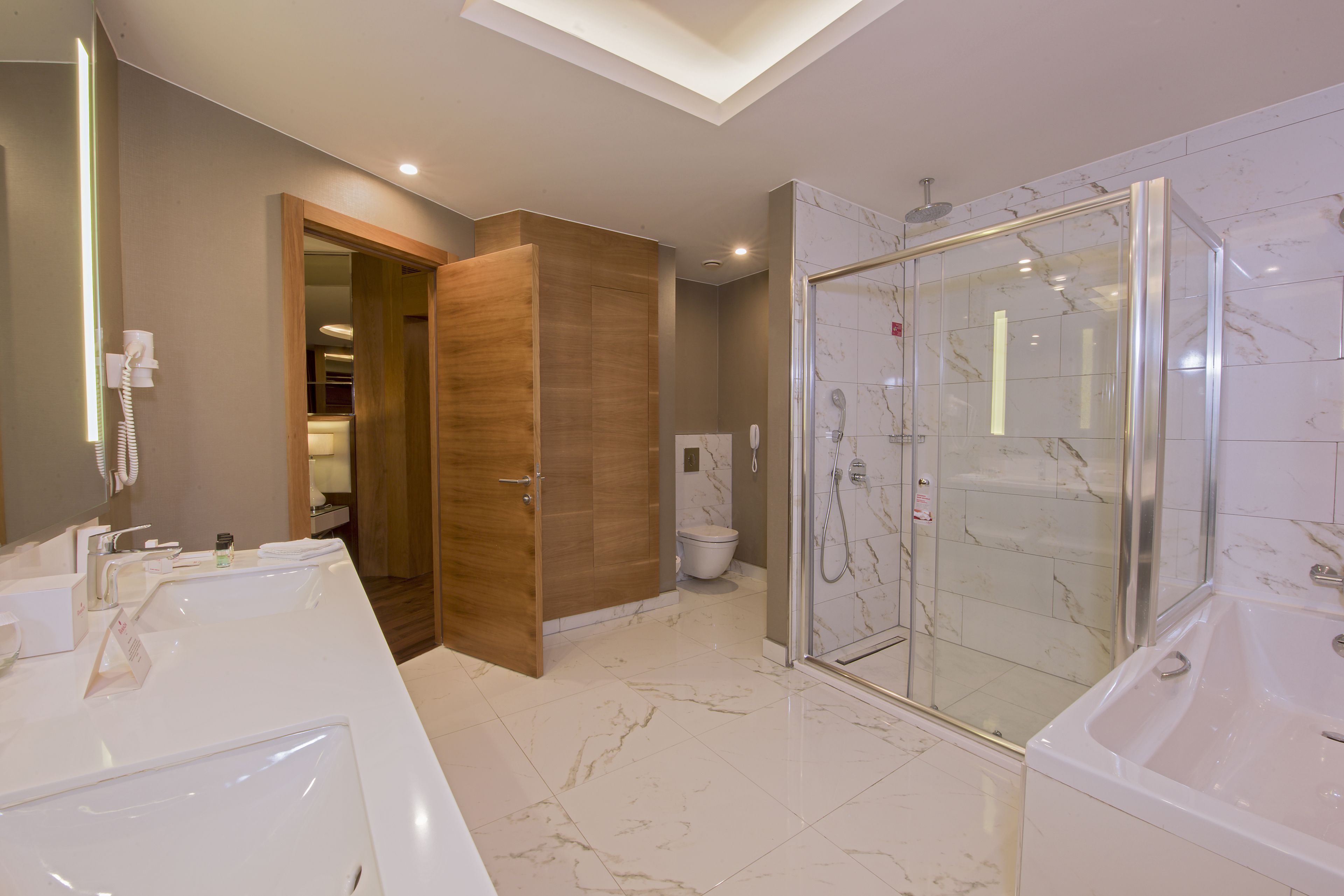Une salle de bain moderne avec deux lavabos, une douche et un espace de douche vitré.