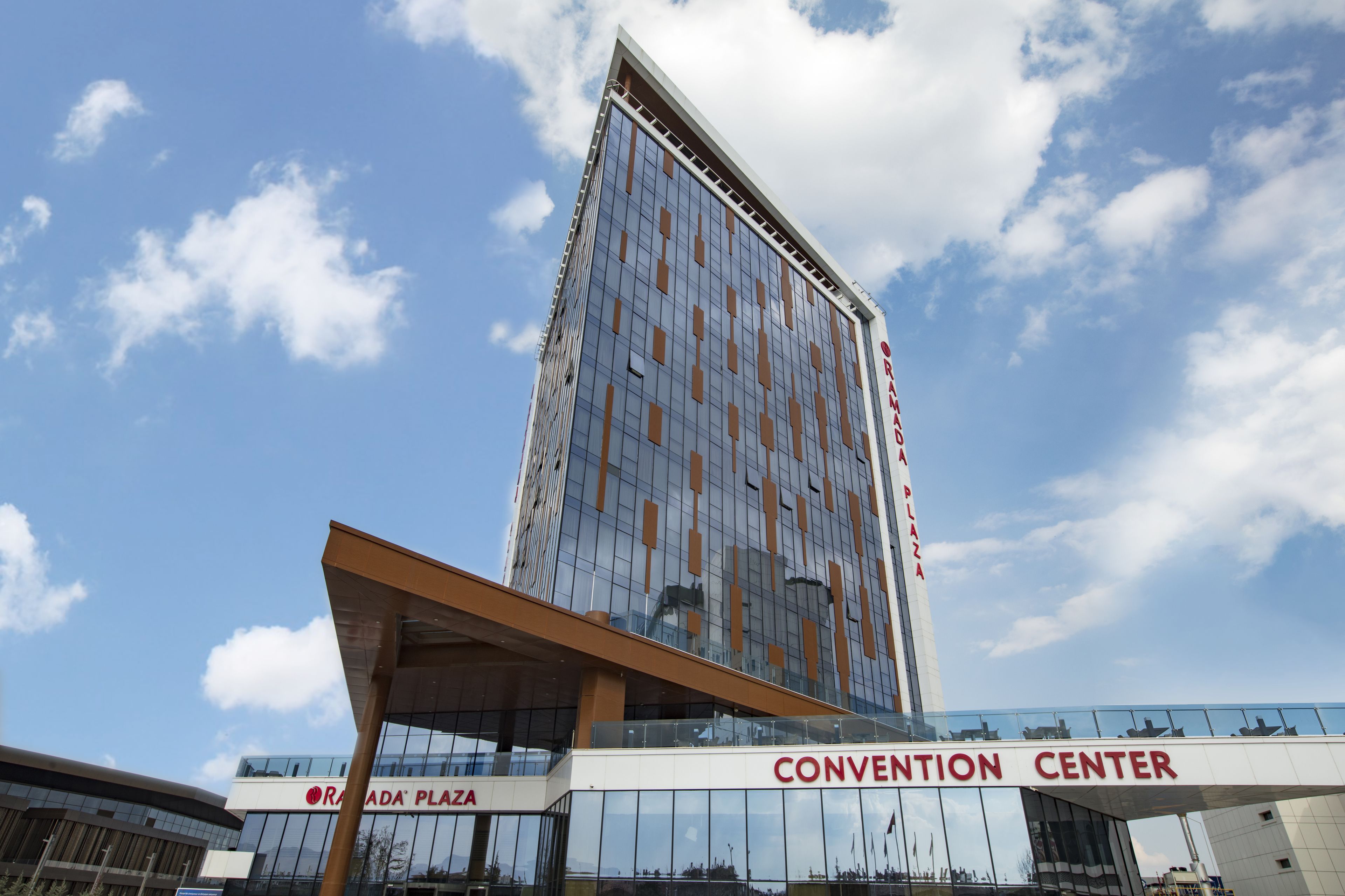A modern building with a glass facade, labeled "CONVENTION CENTER" at the bottom.