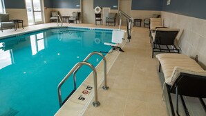Une piscine dont la profondeur est indiquée à 1,5 mètre, avec des chaises longues et un poste de surveillance pour les sauveteurs.