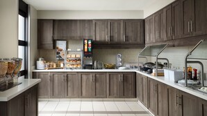 Een moderne keuken met houten kastjes, een koffieapparaat en een ontbijtbalk.