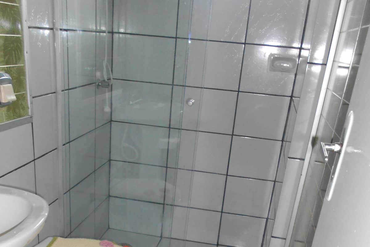 A bathroom with a toilet, sink, and shower area.