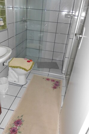 A bathroom with a toilet, sink, and shower area. - Pousada Roses Canela (Canela)