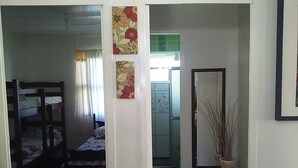 A room with bunk beds, a small bathroom, and a decorative vase. - Pousada Roses Canela (Canela)