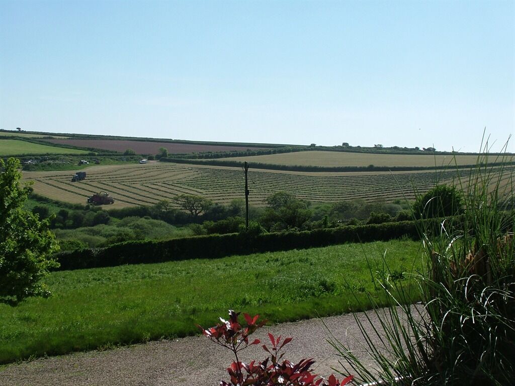 A rural landscape with fields and a clear sky.