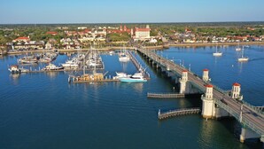 A marina with boats docked, a bridge, and buildings in the background. - Marion Motor Lodge (St. Augustine)