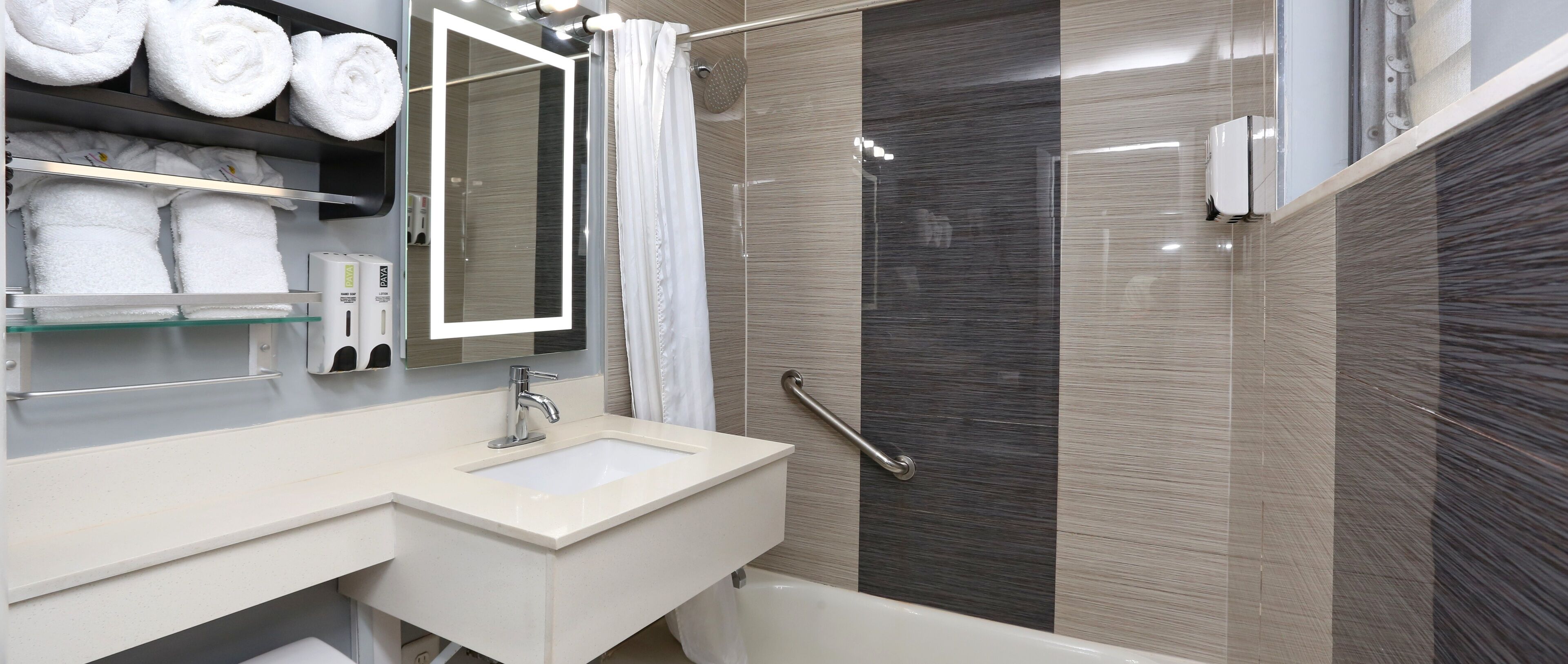 A modern bathroom with a sink, mirror, and shower.