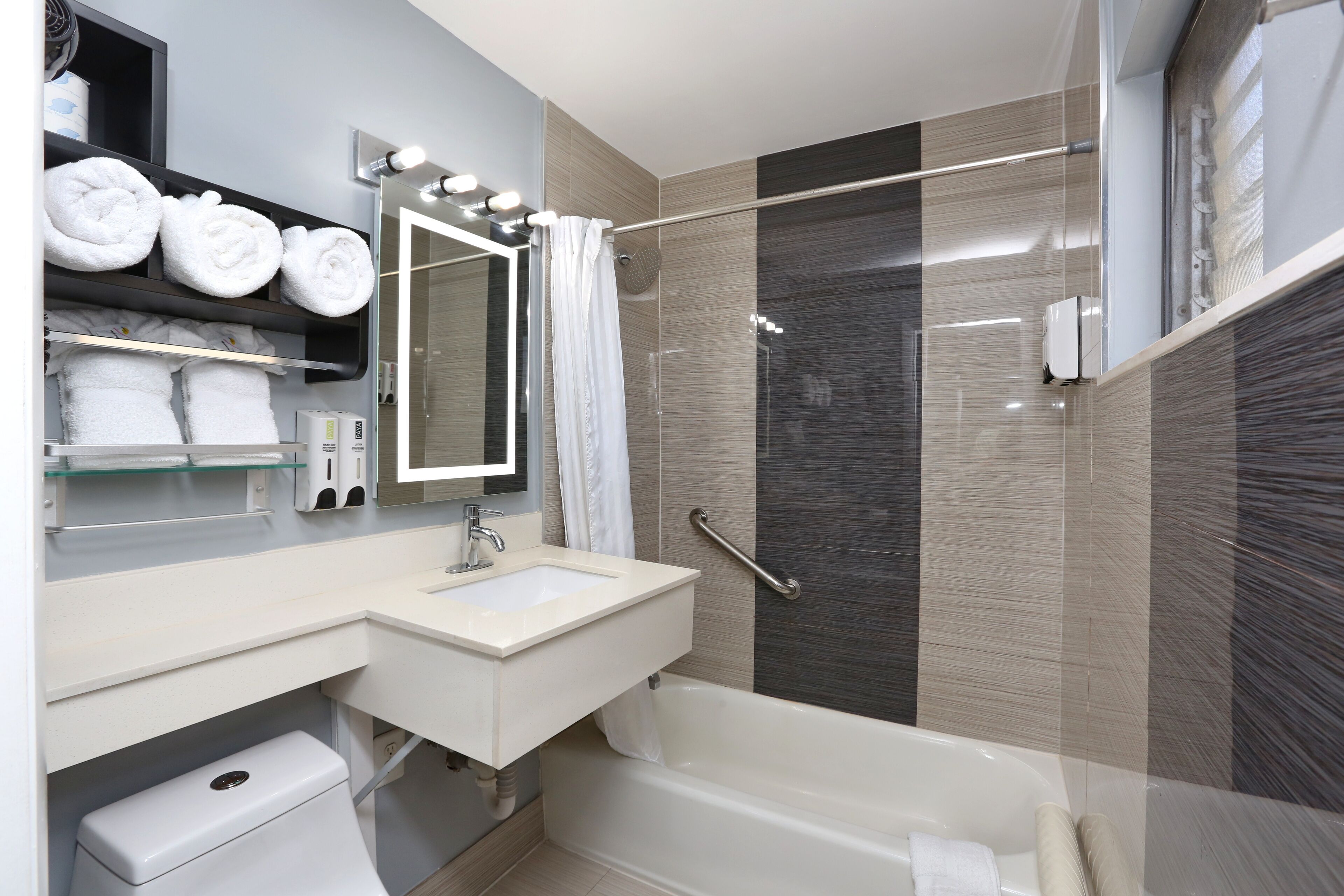 A modern bathroom with a bathtub, a sink, a mirror, and a shower area.