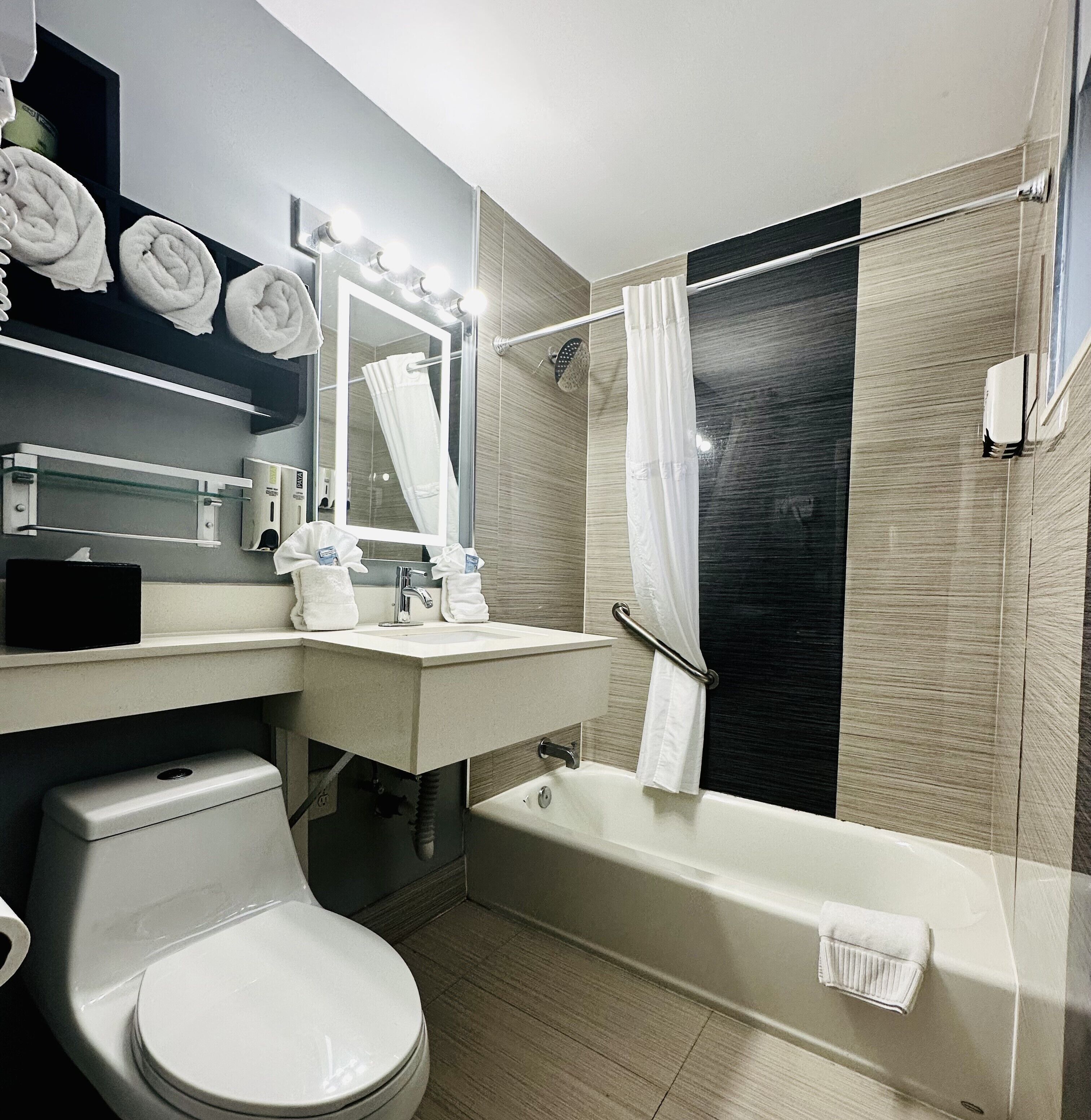 A modern bathroom with a toilet, sink, and bathtub.