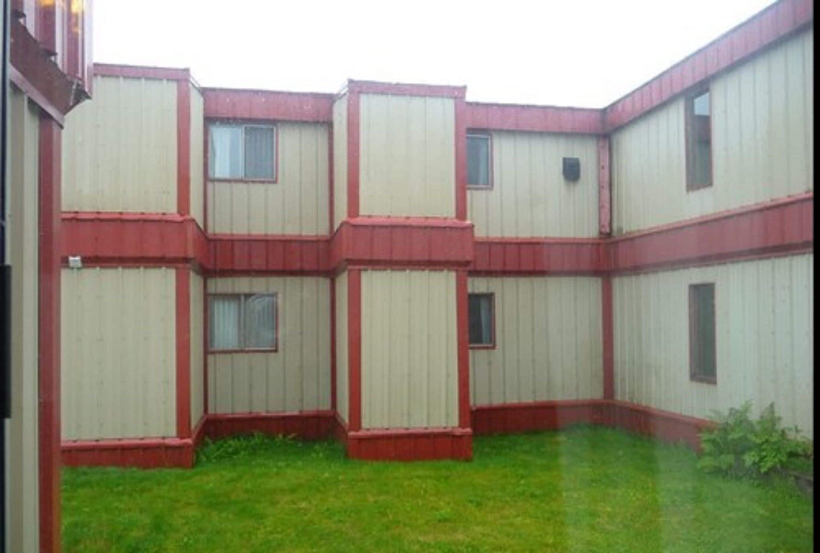 Un edificio de diseño simétrico, con varias unidades rectangulares con ventanas y un patio central.