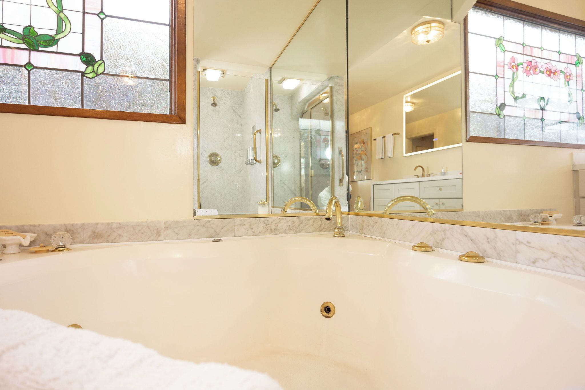 Une salle de bain dotée d’une grande baignoire, d’une douche à parois de verre et d’un comptoir en marbre.