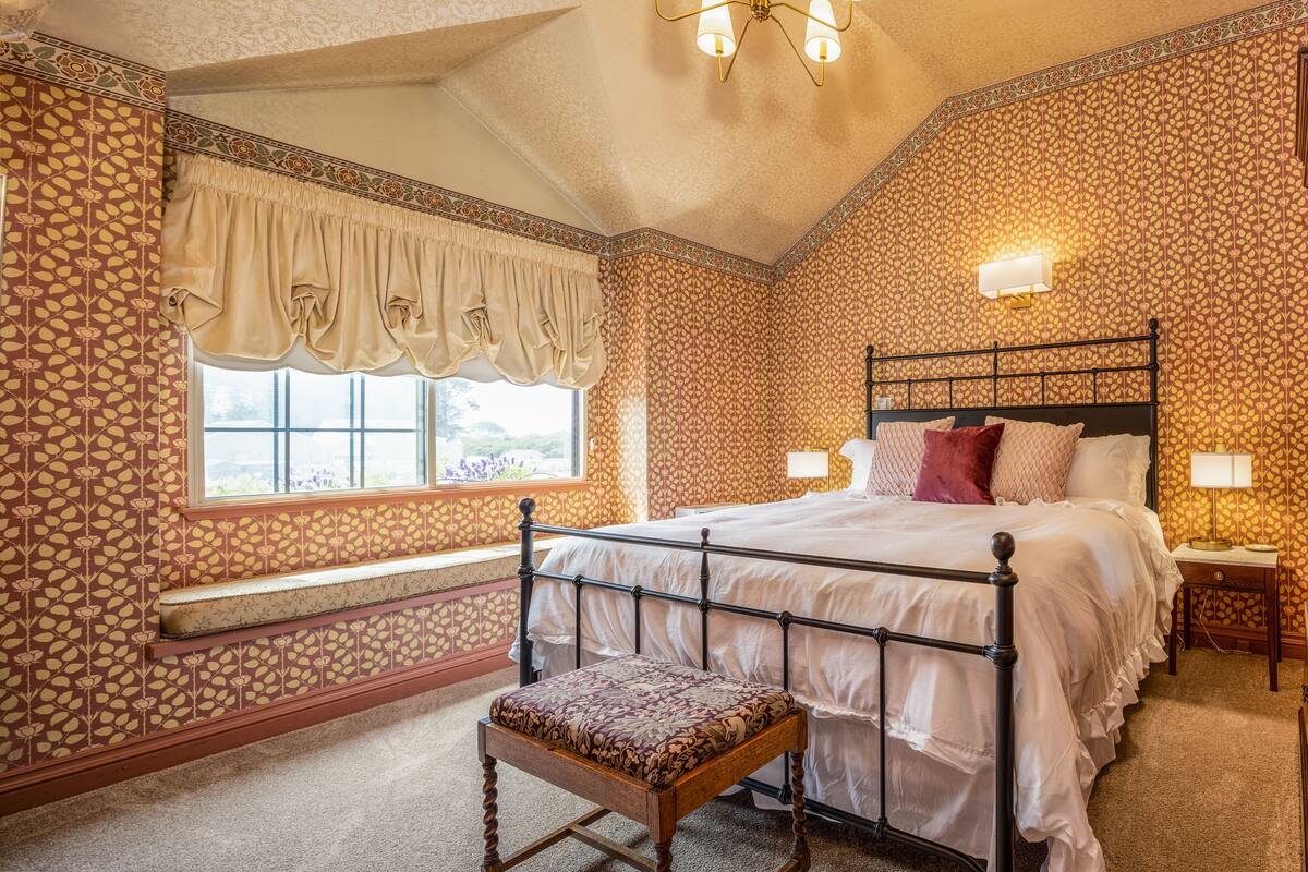 Una camera da letto con un letto, una panca e una finestra.
