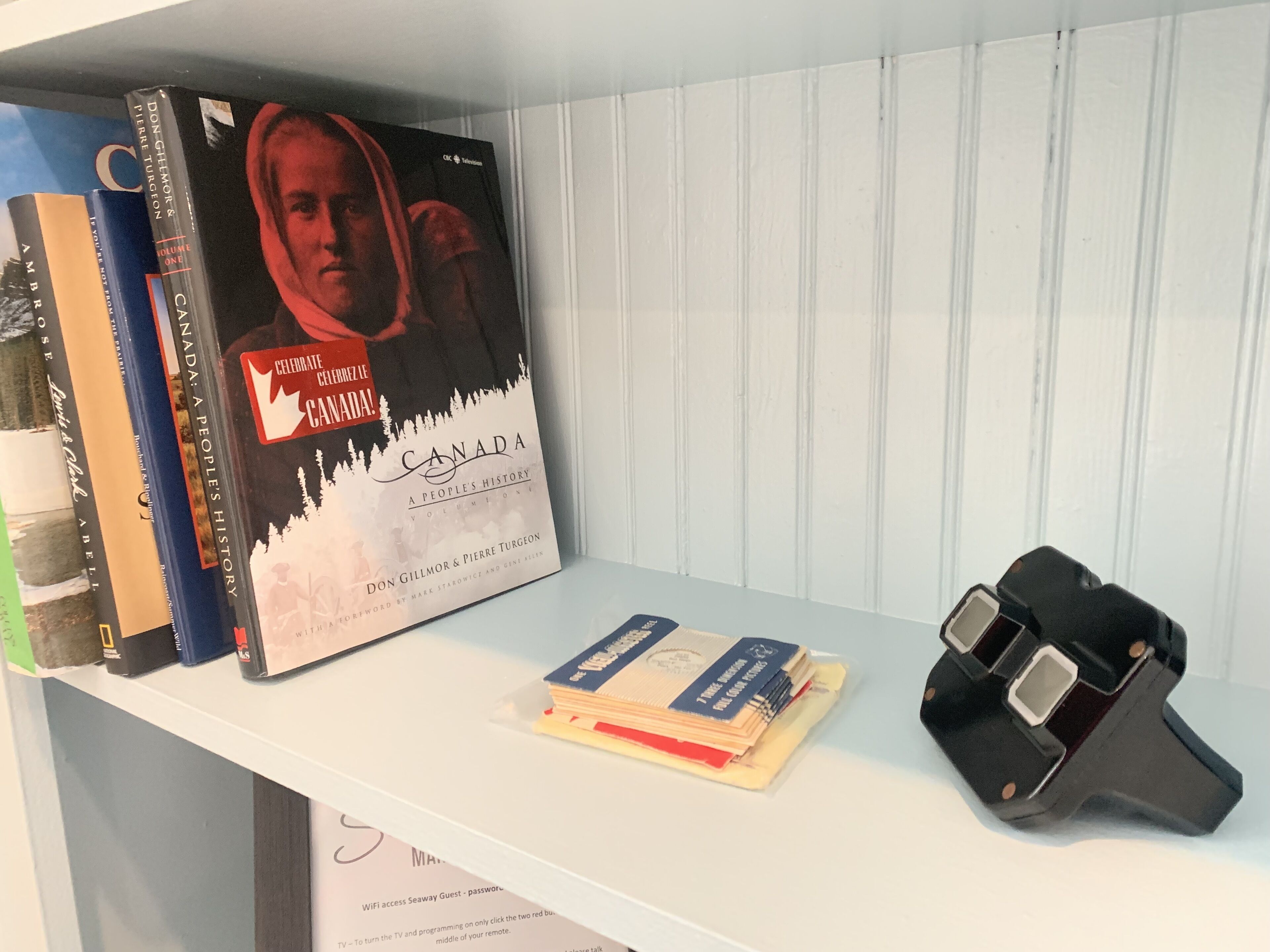 Una estantería con libros y un reproductor de DVD.