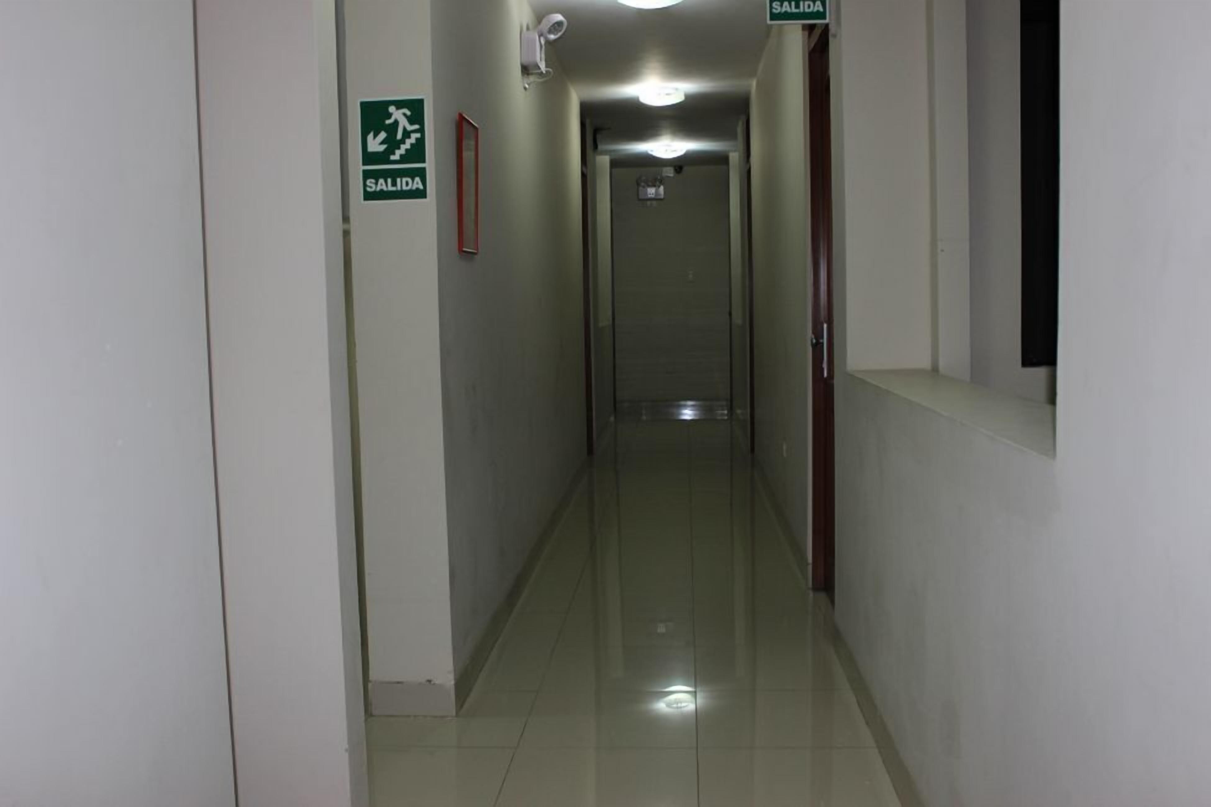 Un pasillo limpio y bien iluminado con un letrero que indica 'SALIDA'.