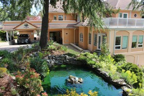 A house with a swimming pool, surrounded by various plants and trees. - Villa Eyrie Resort (Malahat)