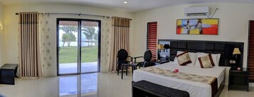 Quarto de hotel com cama, secretária, cadeira e vista para o exterior.