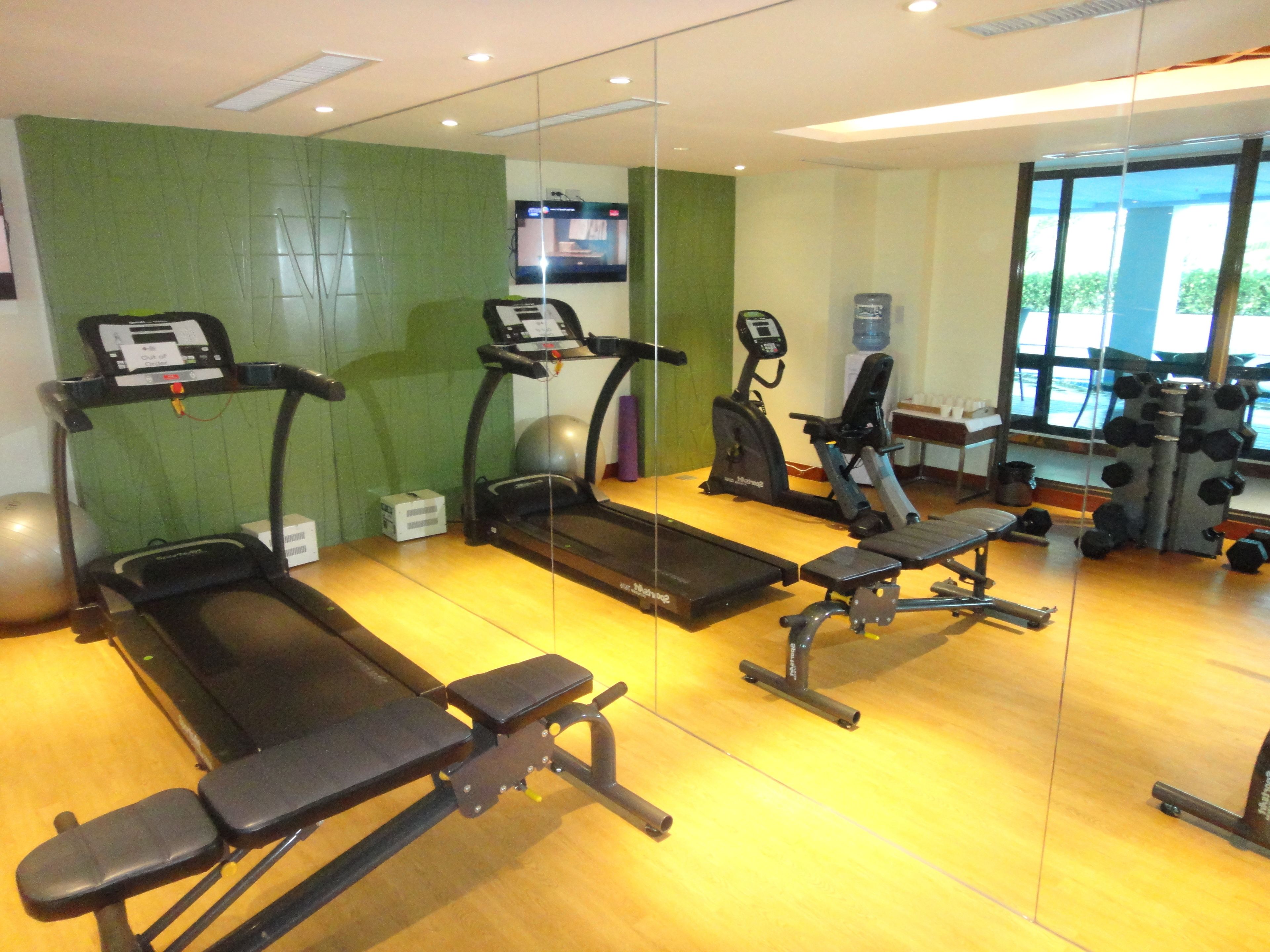 Ein Fitnessstudio mit Laufbändern, Crosstrainern und Gewichtstrainern.