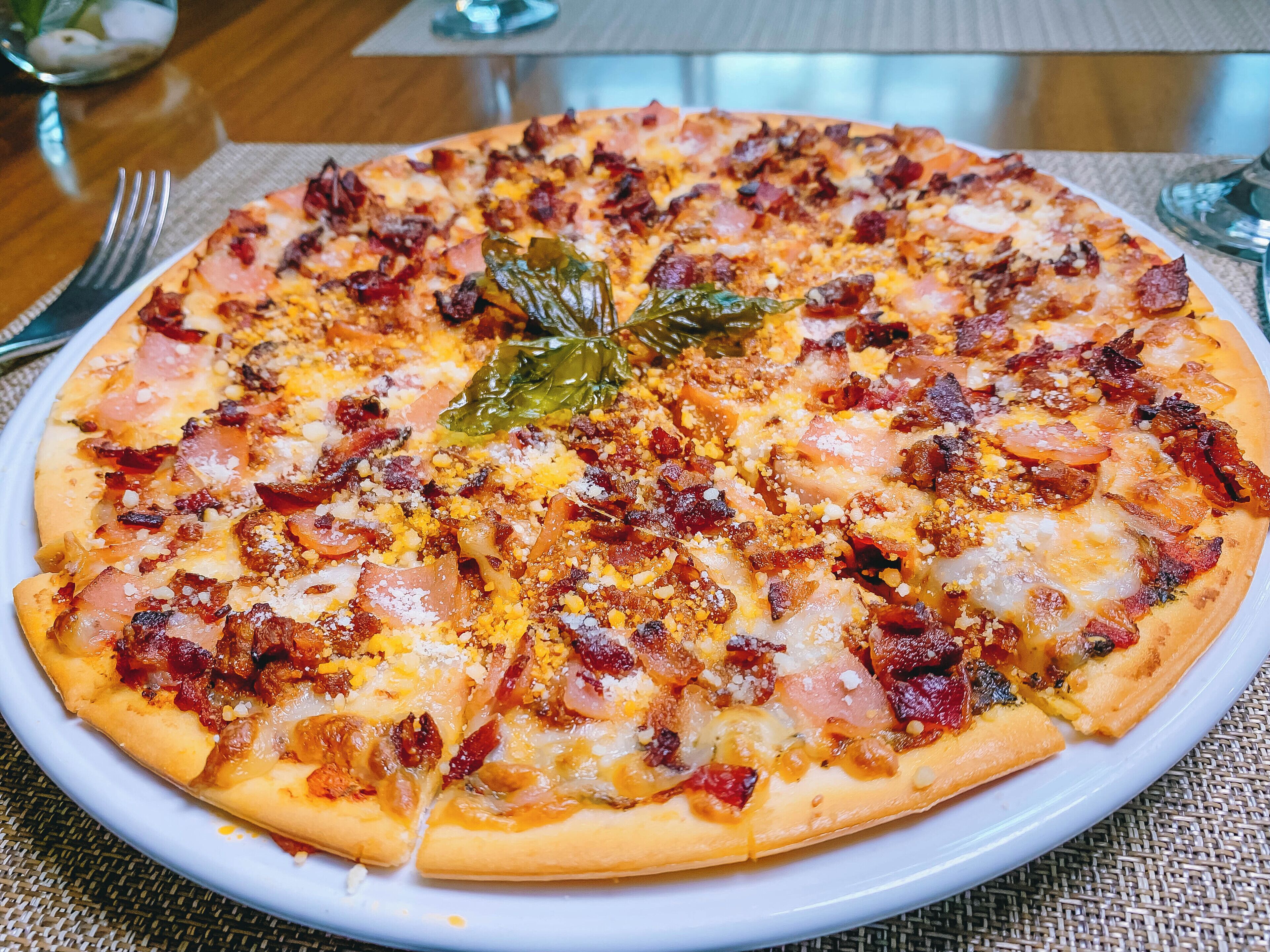 Eine Pizza mit verschiedenen Belägen auf einem weißen Teller.