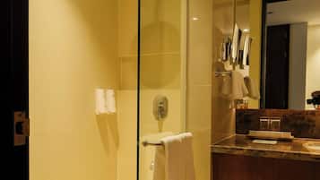 A modern bathroom with a glass-enclosed shower, a wooden vanity, and a large mirror.