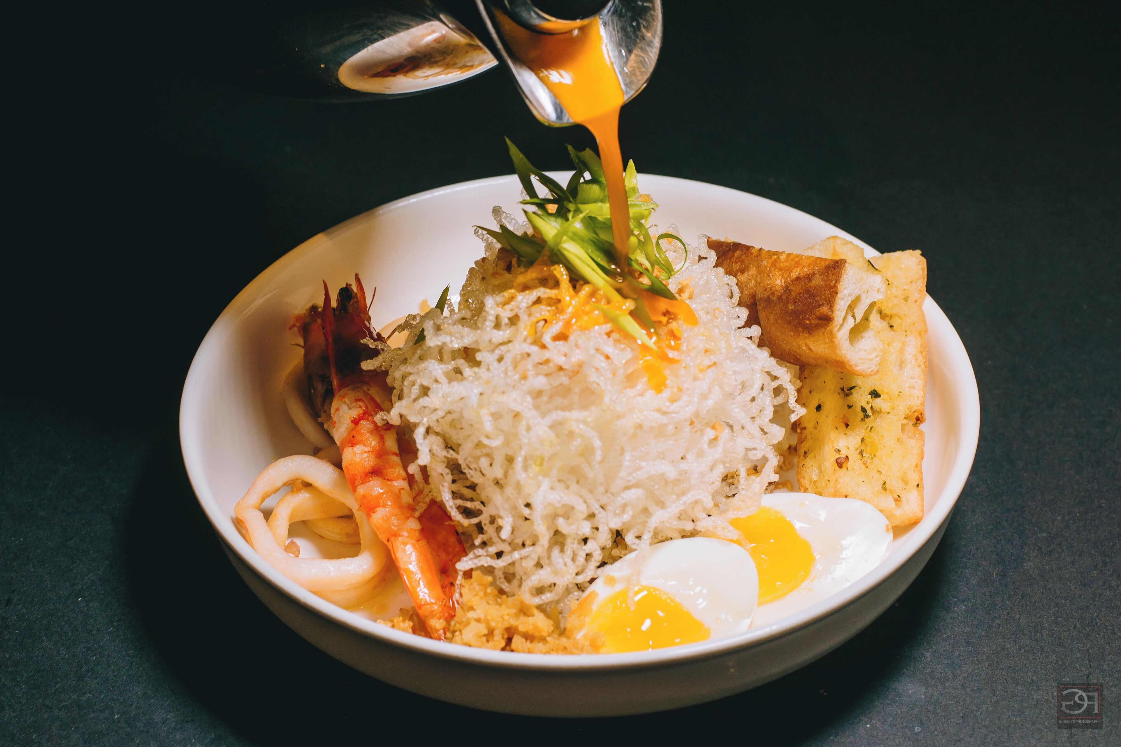 A bowl of food with noodles, egg, and vegetables.