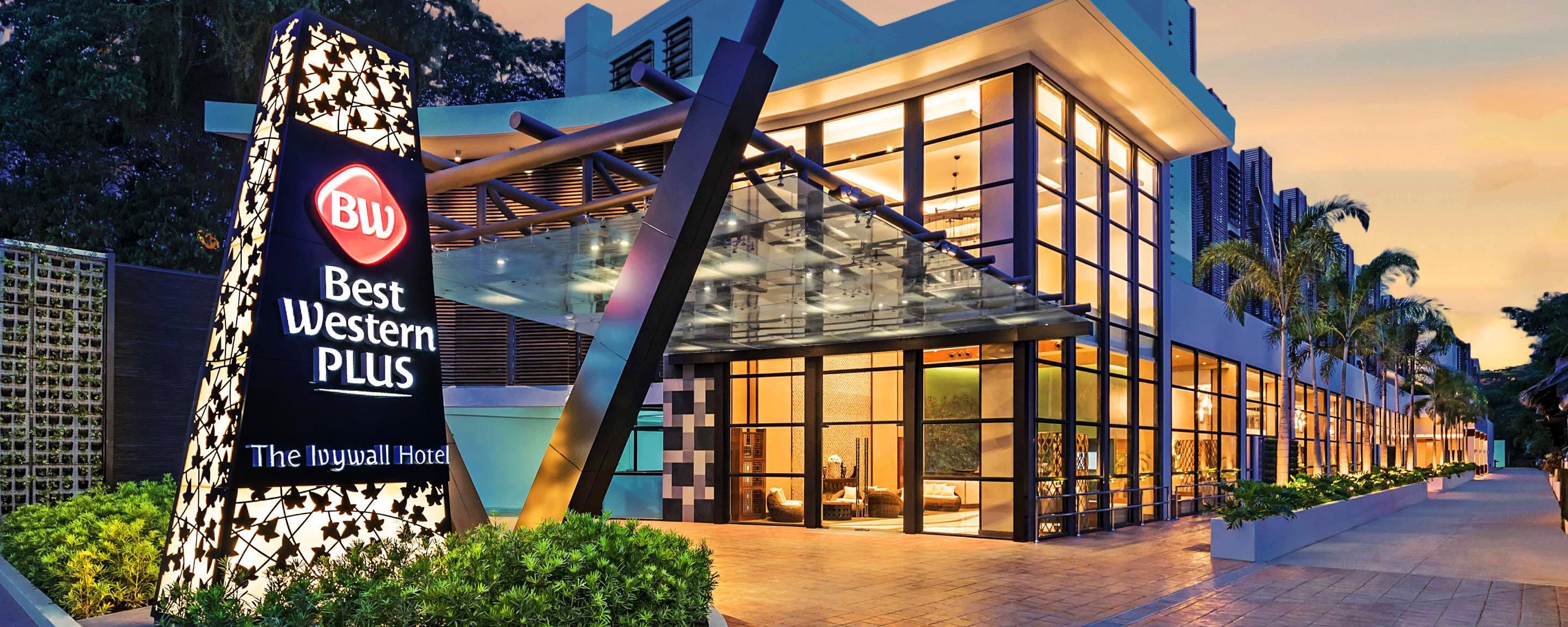 A modern hotel with a glass facade, a prominent sign for 'Best Western Plus', and certifications for GSTC and BUREAU VERITAS.