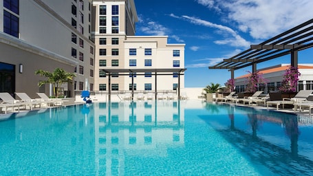 Una piscina al aire libre, sillones reclinables de piscina