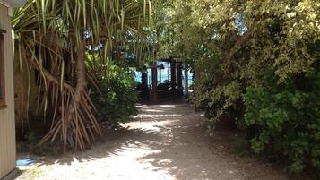 A pathway leading to a covered area with a view of the sea.
