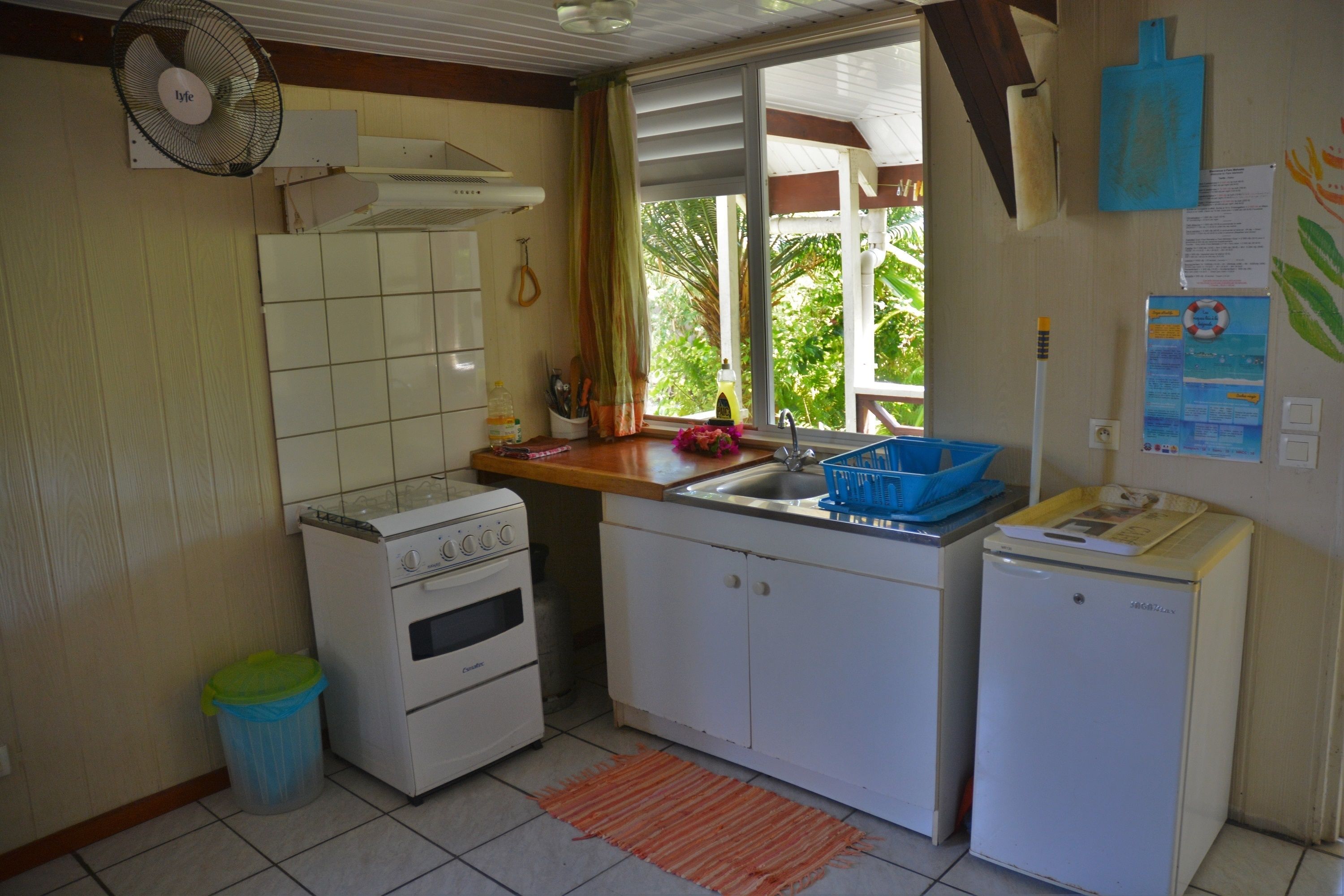 A compact kitchen with a gas stove, a sink, and a small refrigerator.