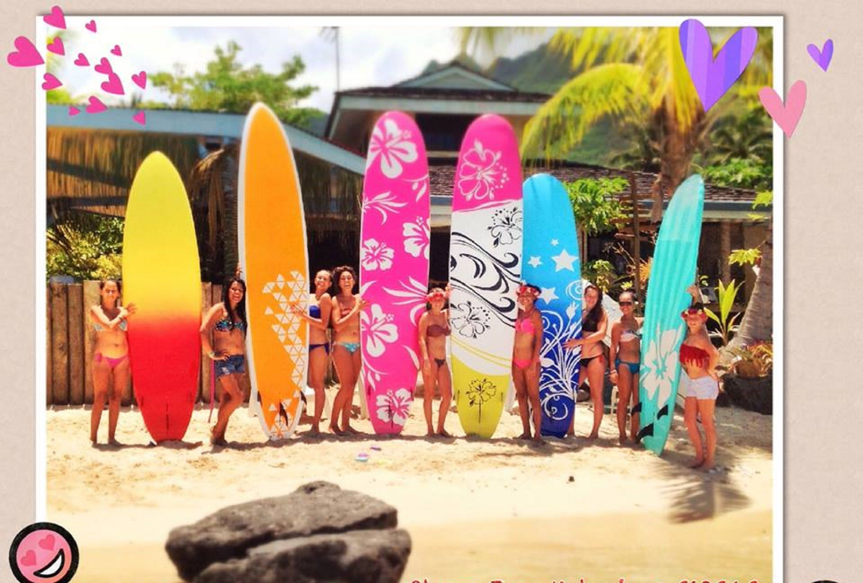 A group of people holding surfboards on a beach.