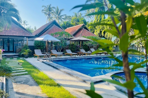 Een buitenzwembad en ligstoelen