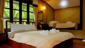 A neatly made bed with white linens, a wooden headboard, and a window with curtains. - Baan Phuthadol (Mae Hong Son)