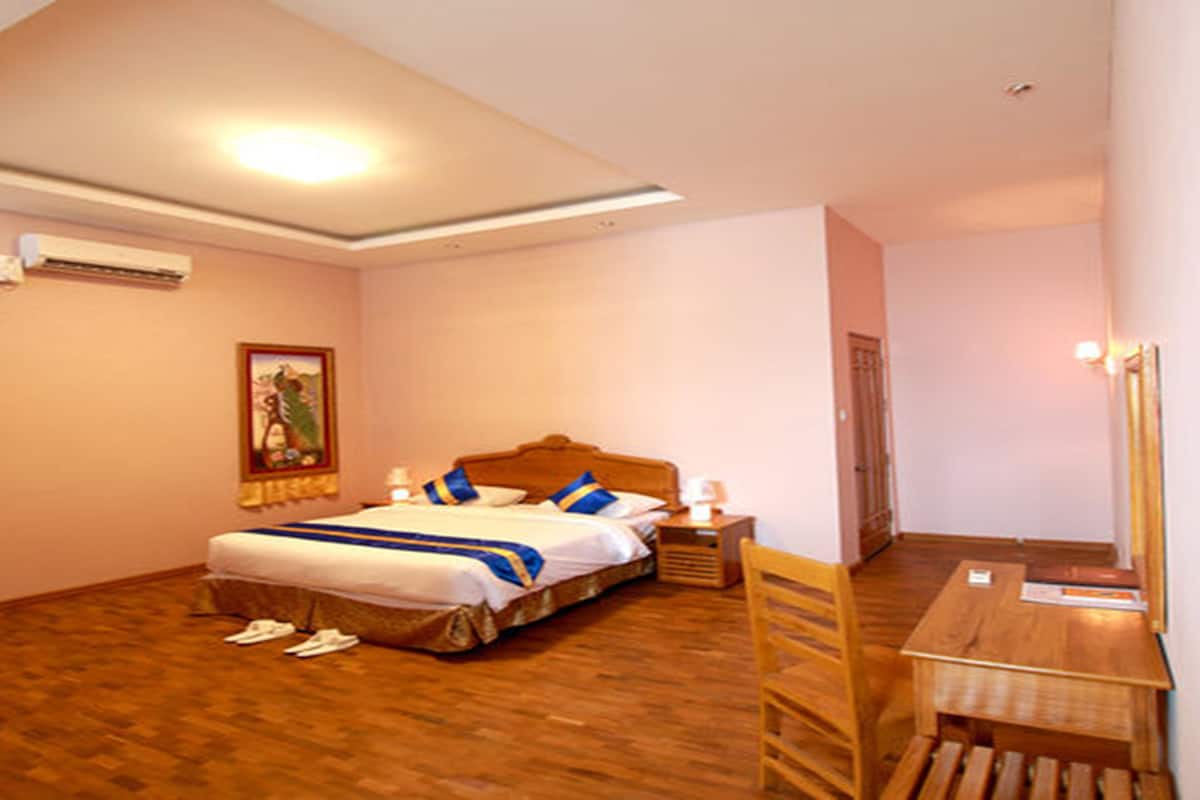 Un dormitorio con cama, mesita de noche, silla y escritorio.