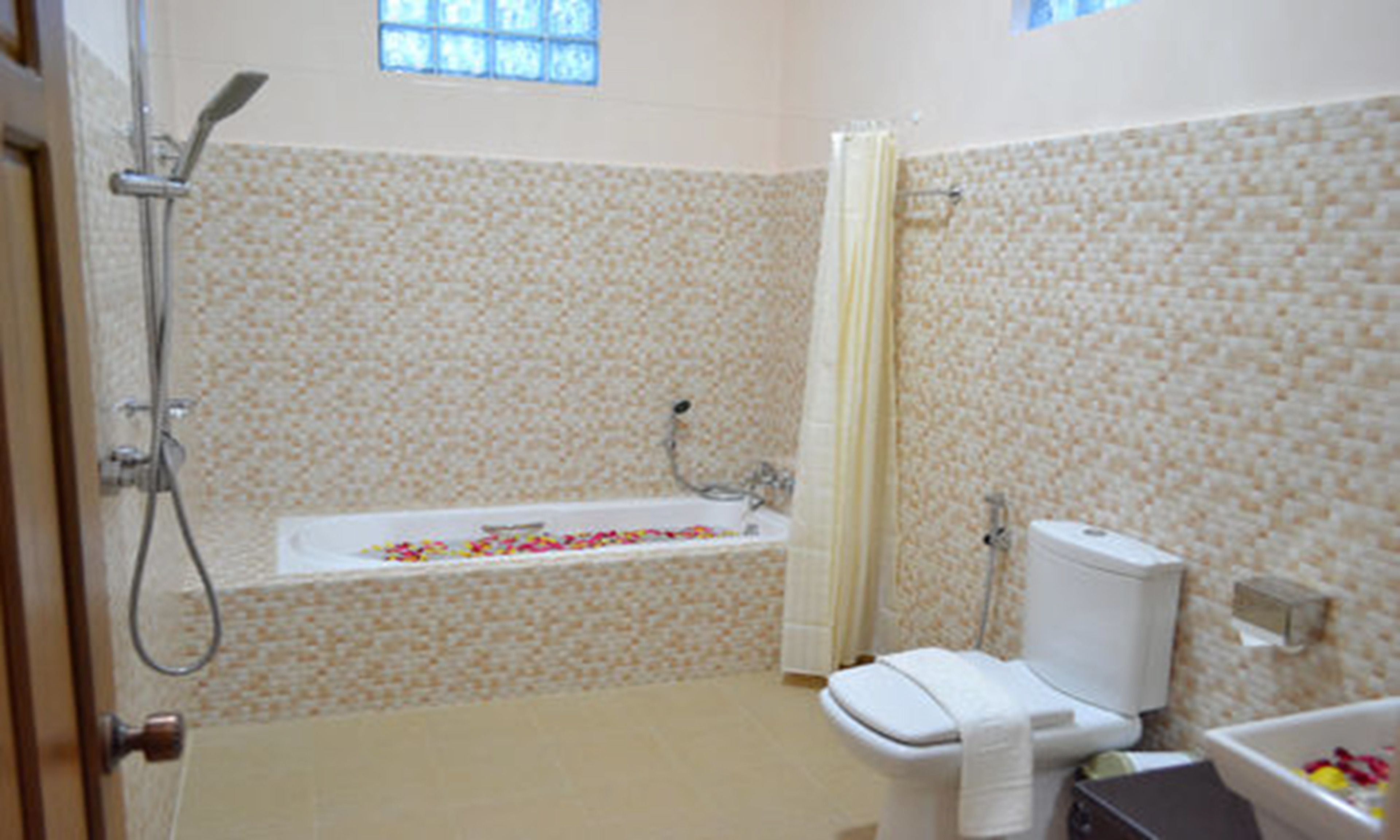 Un baño con bañera, inodoro y ducha.