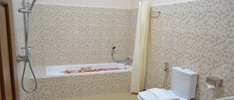 Un baño con bañera, inodoro y ducha.