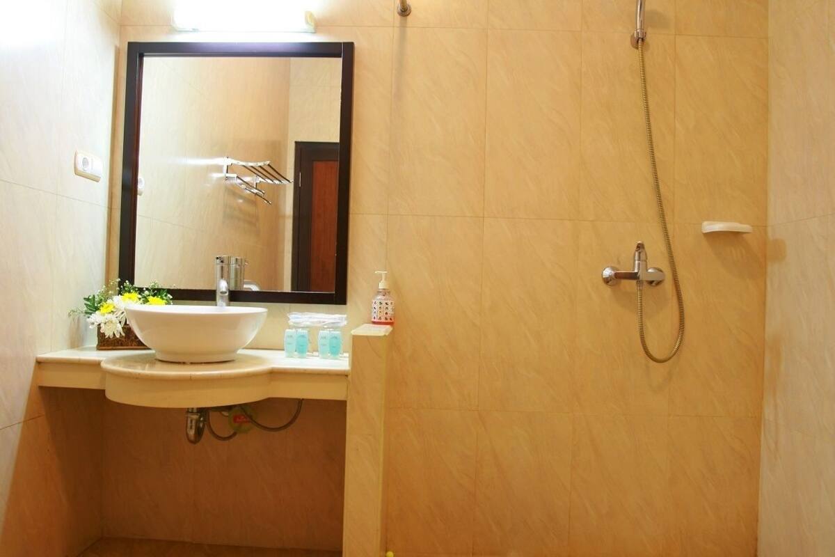 A bathroom with a sink, mirror, and shower.