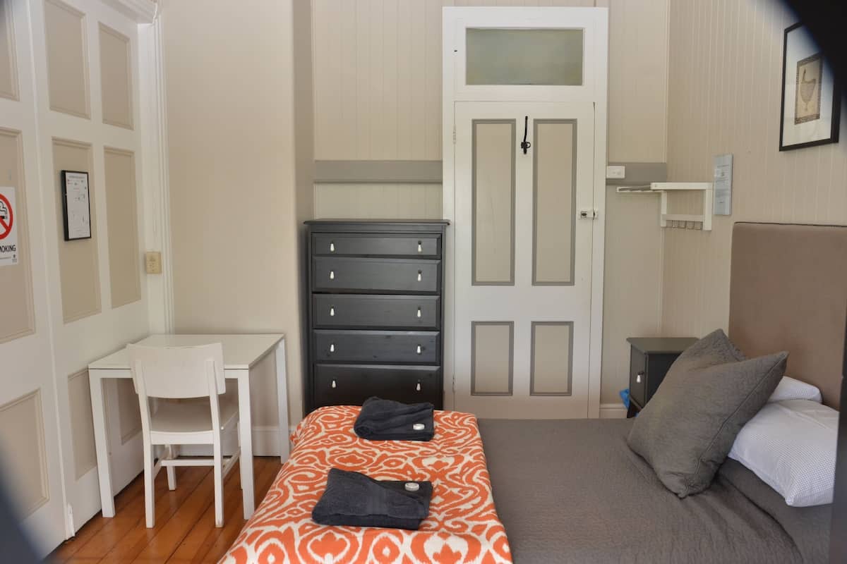 Un dormitorio con una cama, un escritorio y un aparador.