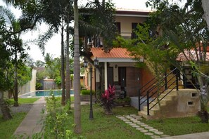 A residential building with a swimming pool, a staircase, and a garden area with various plants. - Morning Star Guest House (Negombo)