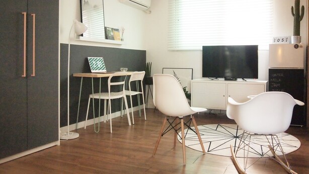 Una cocina moderna con comedor, televisor de pantalla plana y refrigerador decorado con un cactus.