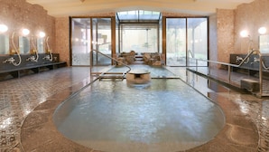 A spa area with a hot tub, seating, and a view of the outdoors.